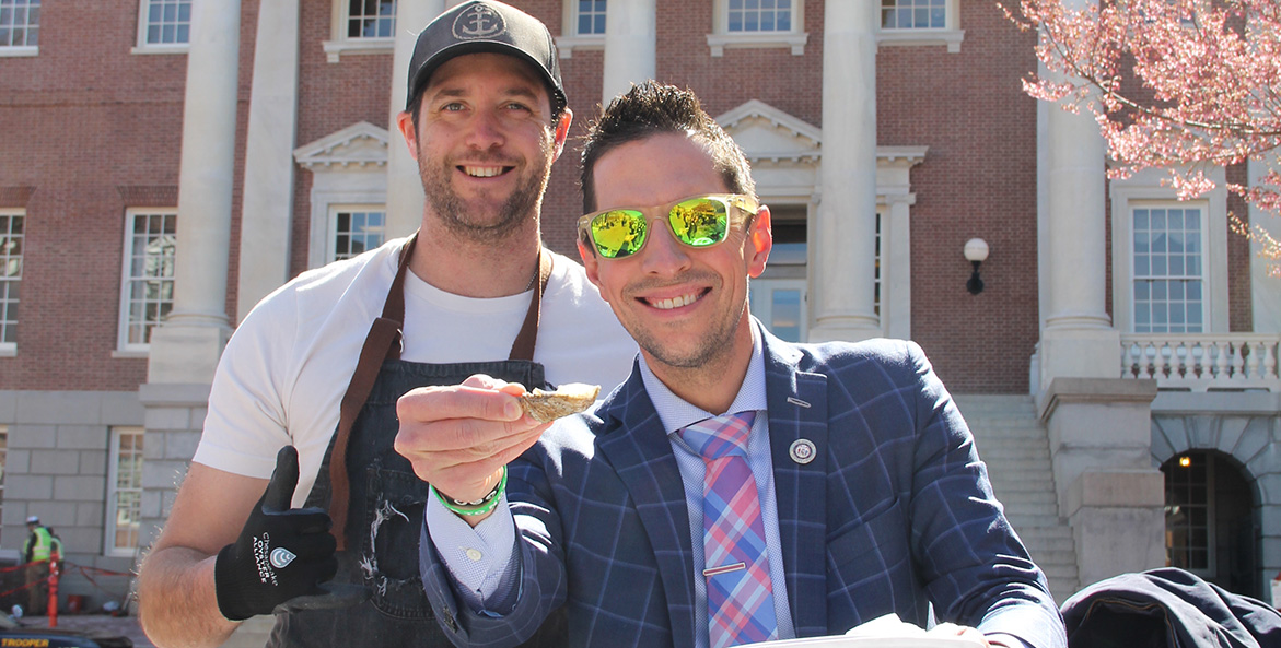 A Maryland legislator gets ready to eat an oyster freshly shucked outside the Annapolis State House.