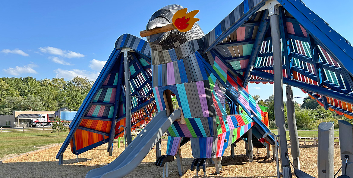 A large multi-colored crow surrounds a sliding board.